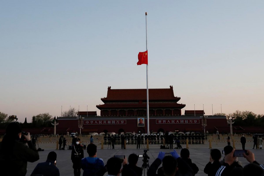 The Chinese national flag flies at half-mast during sunrise at Tiananmen Square in Beijing, as China holds a national mourning for those who died of the coronavirus disease (COVID-19), on the Qingming tomb sweeping festival on April 4, 2020 — cnsphoto via REUTERS