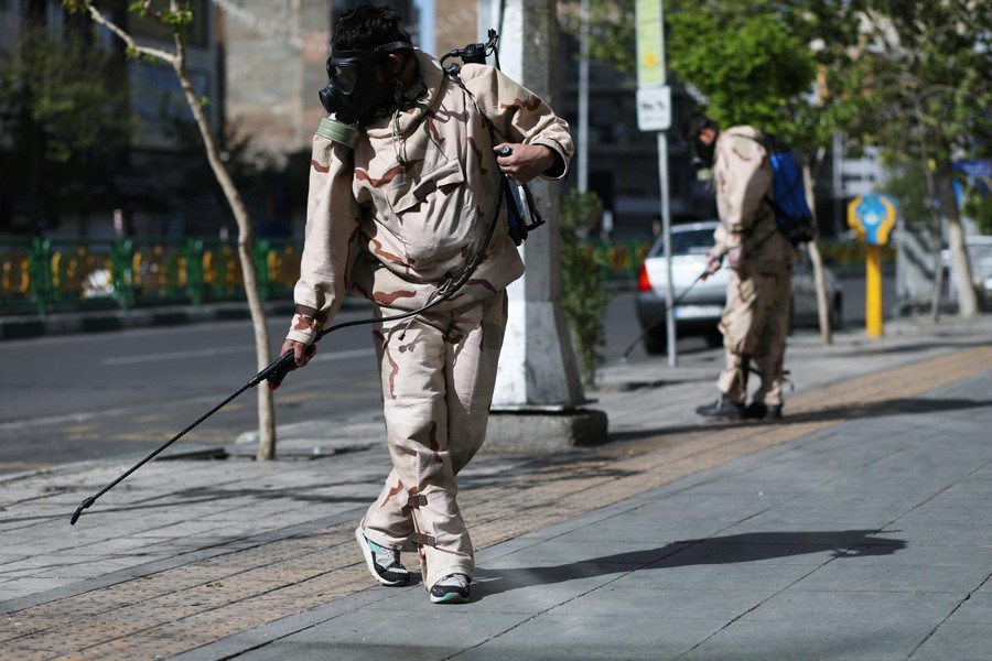 Volunteers from Basij forces wearing protective suits and face masks spray disinfectant on the streets, amid the coronavirus disease (COVID-19) fears, in Tehran, Iran on April 3, 2020 — WANA via REUTERS