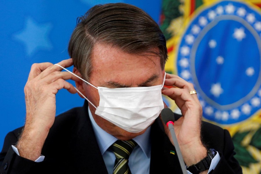 Brazil's Jair Bolsonaro adjusts his protective face mask during a news conference to announce measures to curb the spread of the coronavirus disease (COVID-19) in Brasilia, Brazil on March 18, 2020 — Reuters/Files