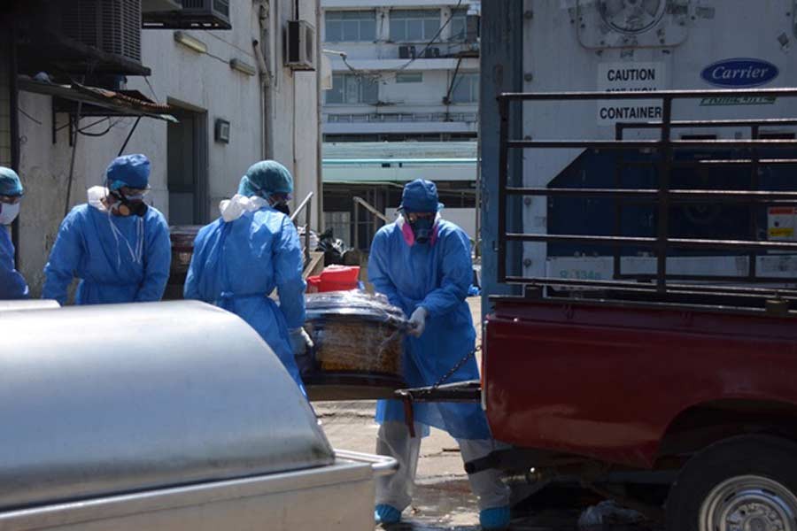 Health workers wearing protective gear load a coffin onto the back of a pick-up truck outside of Teodoro Maldonado Carbo Hospital amid the spread of the coronavirus disease (COVID-19), in Guayaquil, Ecuador Apr 3, 2020. REUTERS