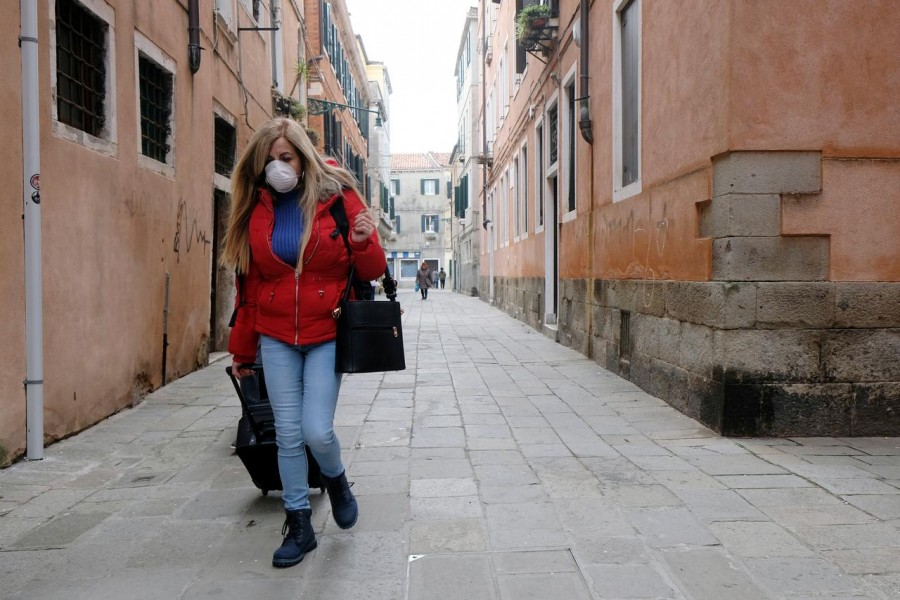 A woman wears a protective face mask as she walks in Venice, Italy February 24, 2020. REUTERS/Manuel Silvestri