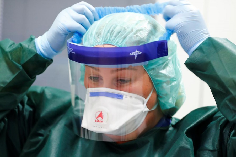 Canan Emcan, 31, chief nurse of the infection and virologist ward of Essen University Hospital puts on protection gear worn in case of coronavirus patients during a media event in Essen, Germany on March 5, 2020 — Reuters/Files