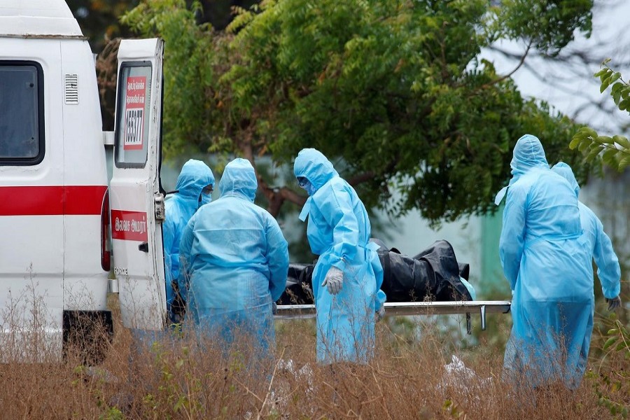 Municipal workers and relatives wearing protective suits remove the body of a woman who died due to the coronavirus disease (COVID-19) from an ambulance for her burial at a graveyard in Chennai, India, April 08, 2020. – Reuters