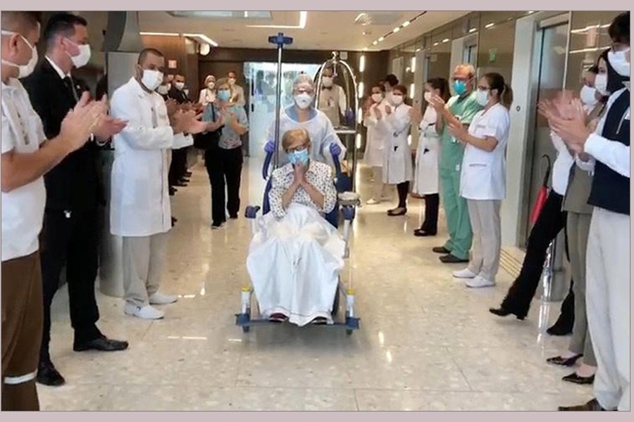 97-year-old Brazilian Gina Dal Colleto, the oldest known survivor of the coronavirus disease (COVID-19) in Brazil, is pushed in a wheelchair out of Sao Paulo's Vila Nova Star hospital to applause from doctors and nurses on April 12, 2020, in this still image obtained from a social media video — Courtesy of Rede D'Or Sao Luiz/Social Media via REUTERS