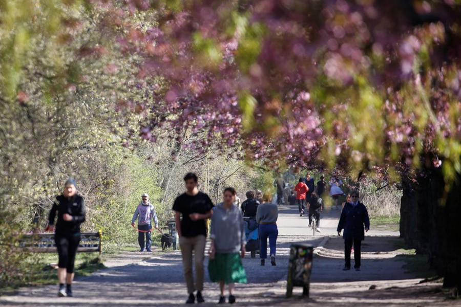 People walk under blooming cherry blossoms in a park in the Berlin district of Treptow on Easter Sunday amid the coronavirus outbreak, Germany on April 12, 2020 — Reuters photo