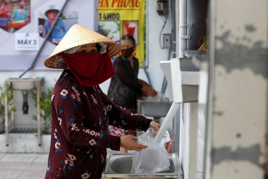 A woman fills a plastic bag with rice from a 24/7 automatic rice dispensing machine 'Rice ATM' during the outbreak of the coronavirus disease (COVID-19), in Ho Chi Minh, Vietnam on April 11, 2020 — Reuters photo