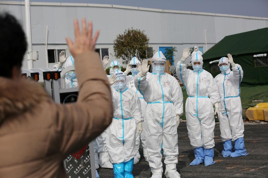 Medical personnel in protective suits wave hands to a patient who is discharged from the Leishenshan Hospital after recovering from the novel coronavirus, in Wuhan, the epicentre of the novel coronavirus outbreak, in Hubei province, China on March 1, 2020 — Reuters/Files