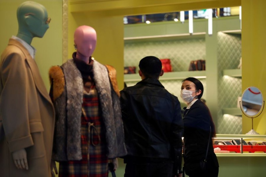 A shop assistance wearing a protective face mask following an outbreak of the coronavirus talks to a customer at shopping mall in Tokyo, Japan, February 29, 2020. REUTERS/Kim Kyung-Hoon/File Photo