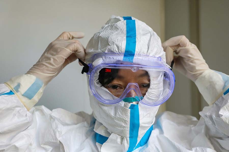 A doctor puts on protective goggles before entering the isolation ward at a hospital, following the outbreak of a new coronavirus in Wuhan, Hubei province, China on January 30, 2020. Reuters