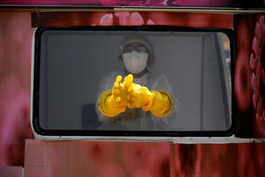 A medical worker sitting inside a mobile test van for the coronavirus disease (COVID-19) waits to collect swabs from people to test, on the outskirts of Ahmedabad, India, April 27, 2020. — Reuters