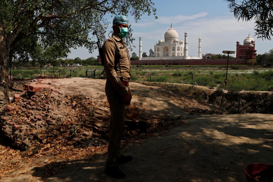 A policeman wearing a protective mask stands guard near the historic Taj Mahal during a nationwide lockdown to slow the spread of the coronavirus disease (COVID-19), in Agra, India, April 23, 2020. REUTERS/Adnan Abidi