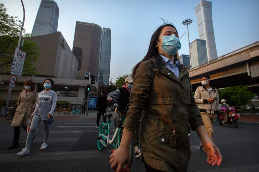 People seen walking to work in Beijing as China is gradually getting back to normalcy — AP/Files