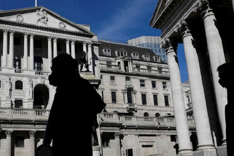 People wearing masks walk past the Bank of England, as the spread of the coronavirus disease (COVID-19) continues, in London, Britain, March 23, 2020. — Reuters/Files