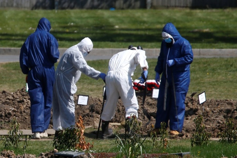 Workers wearing protective suits bury the body of a person at the Muslim cemetery Eternal Gardens in Kemnal Park Cemetery in Chislehurst, as the spread of the coronavirus disease (COVID-19) continues, London, Britain April 23, 2020. — Reuters