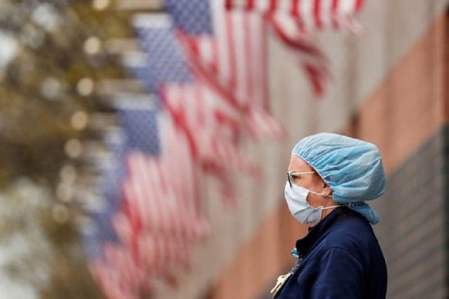 A nurse wearing personal protective equipment watches an ambulance driving away outside of Elmhurst Hospital during the ongoing outbreak of the coronavirus disease (COVID-19) in the Queens borough of New York, US, April 20, 2020. — Reuters/Files