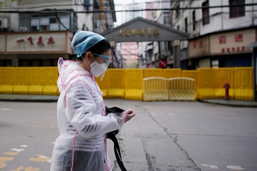 A woman wearing a face mask walks at a residential area blocked by barriers in Wuhan, Hubei province, the epicentre of China's coronavirus disease (COVID-19) outbreak on April 03, 2020 — Reuters/Files