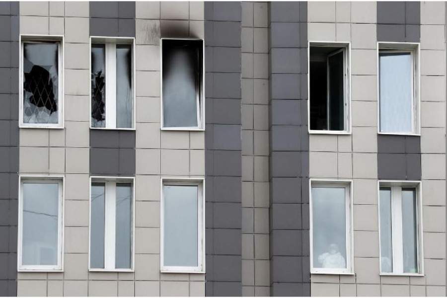 A medical specialist is seen in a window after a fire, which killed five novel coronavirus patients in an intensive care unit, at a hospital in Saint Petersburg, Russia May 12, 2020. REUTERS/Anton Vaganov