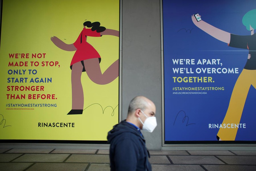 A man wearing a face mask walks past billboards of La Rinascente department store, which is due to reopen with social distancing measures applied, after it was closed because of the coronavirus outbreak in Milan, Italy on May 16, 2020 — Reuters photo