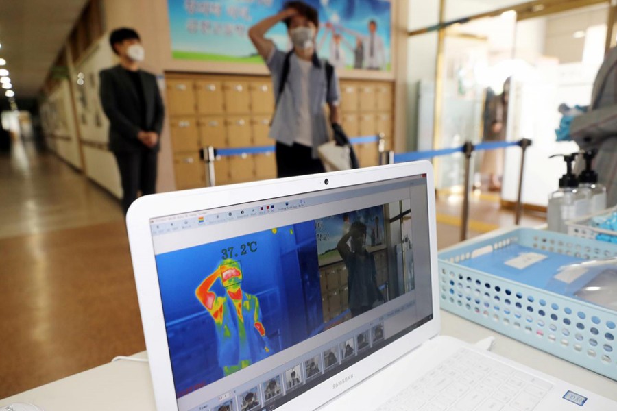 A students gets his temperature checked with a thermal imaging camera as a high school reopens, following the global outbreak of coronavirus disease (COVID-19), in Chungju, South Korea on May 20, 2020 — Yonhap via REUTERS