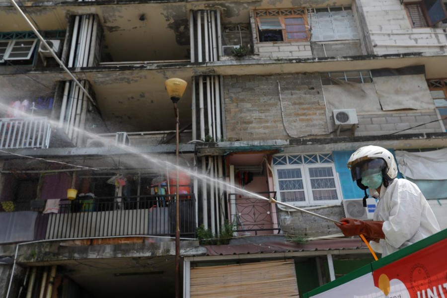 A Red Cross personnel wearing a protective suit sprays disinfectant in a densely populated neighbourhood area, amid the spread of the coronavirus disease (COVID-19) in Jakarta, Indonesia, April 4, 2020. REUTERS/Willy Kurniawan