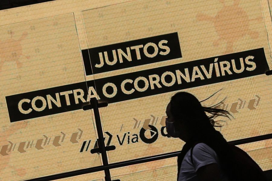 A woman passes by a placard reading "Together against coronavirus" in Sao Paulo, Brazil, on May 20, 2020. (Xinhua/Rahel Patrasso)