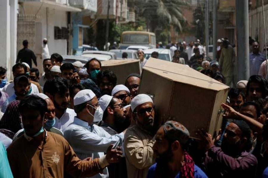 People carry the coffins of husband and wife who were killed in a plane crash, during a funeral in Karachi, Pakistan May 23, 2020. REUTERS