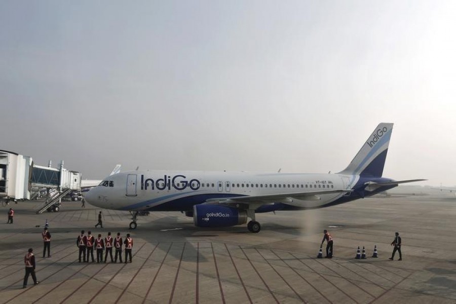 Indigo Airlines' ground staff stand next to an aircraft after it arrived at the Srinagar airport November 21, 2014. REUTERS/Adnan Abidi/Files