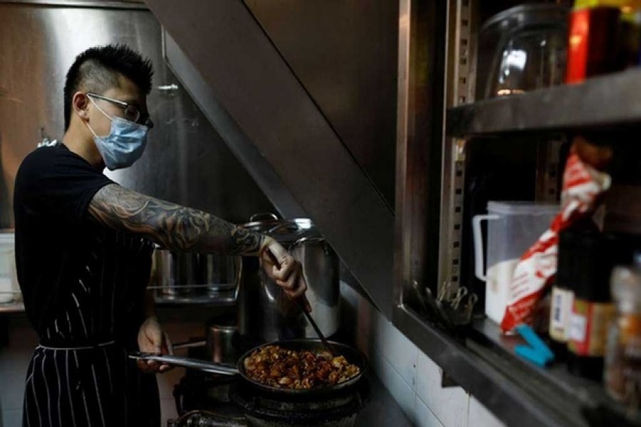 Jason Chua cooks in his stall at Hong Lim Market & Food Centre, amid the coronavirus disease outbreak in Singapore on Apr 27. REUTERS  Previous