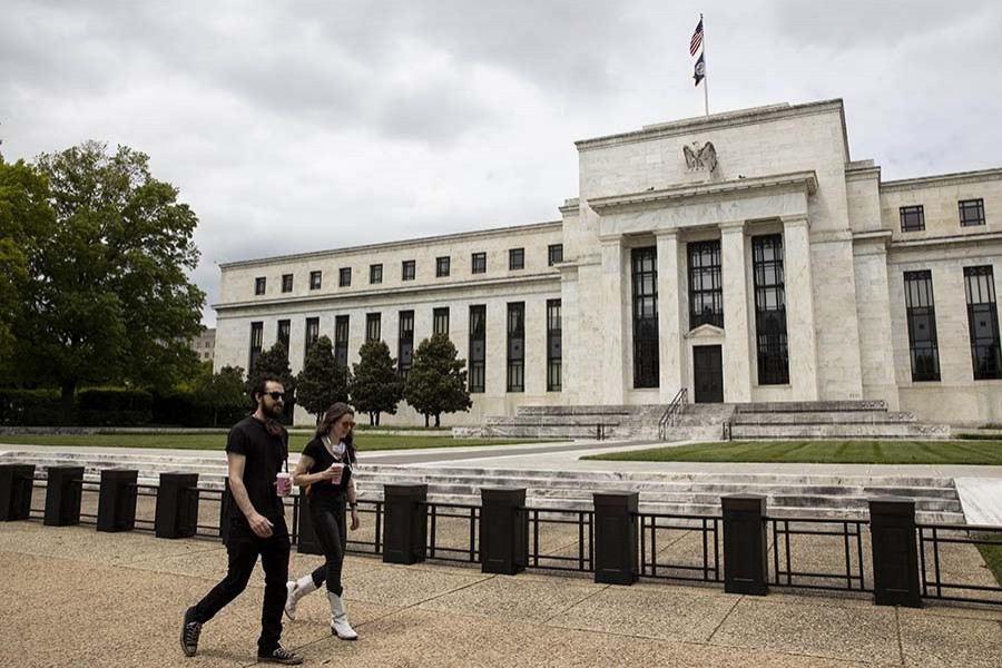 People walk past the U.S. Federal Reserve building in Washington D.C., the United States, May 21, 2020. (Photo by Ting Shen/Xinhua)