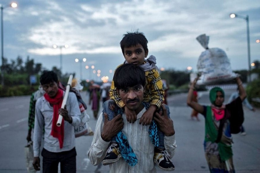 Dayaram Kushwaha, a migrant worker, carries his 05-year-old son, Shivam, on his shoulders as they walk along a road to return to their village, during a 21-day nationwide lockdown to limit the spreading of coronavirus, in New Delhi, India, March 26, 2020. — Reuters/Files