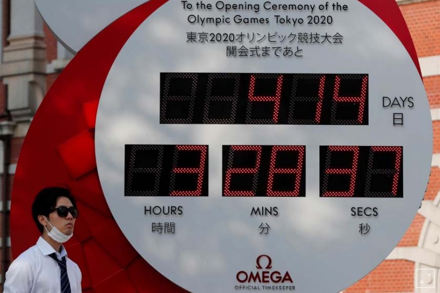 FILE PHOTO: A man wearing a protective mask walks past a countdown clock for the Tokyo 2020 Olympic Games amid the coronavirus disease (COVID-19) outbreak in Tokyo, Japan June 4, 2020. REUTERS/Kim Kyung-Hoon