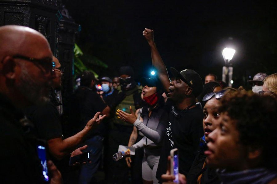 Several men stand at the locked gates of Jackson Square, where a statue of Andrew Jackson resides, and had brief heated words with demonstrators who had gathered around the square during a protest against the death in Minneapolis police custody of George Floyd, in New Orleans, Louisiana, U.S., June 5, 2020. Picture taken June 5, 2020. REUTERS/Kathleen Flynn   