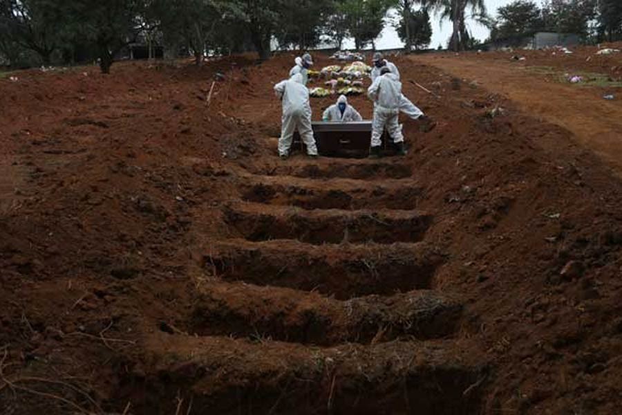 Gravediggers wearing protective suits bury the coffin of 48-years-old Jose Soares, who died from the coronavirus disease (COVID-19), at Sao Luiz cemetery, in Sao Paulo, Brazil on Thursday. –Reuters file photo