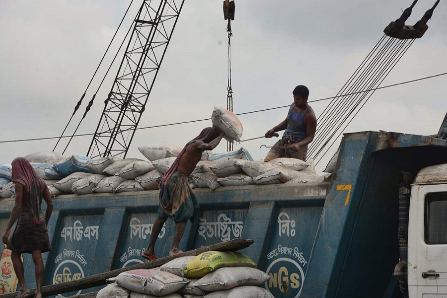 Labourers load goods onto a truck at Majhirghat area in Chattogram