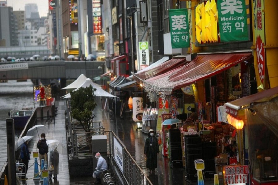 A woman, wearing a protective mask following an outbreak of the coronavirus disease (COVID-19), walks on an almost empty street in the Dotonbori entertainment district of Osaka, Japan, March 14, 2020. — Reuters/Files