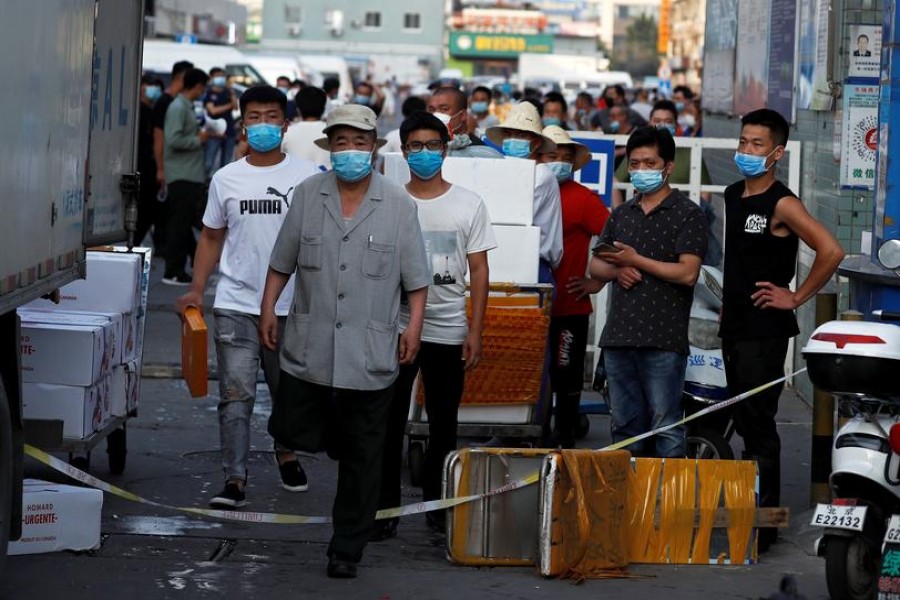 People are wearing face masks inside the Jingshen seafood market which has been closed for business after new coronavirus infections were detected, in Beijing, China, June 12, 2020. REUTERS/Thomas Peter