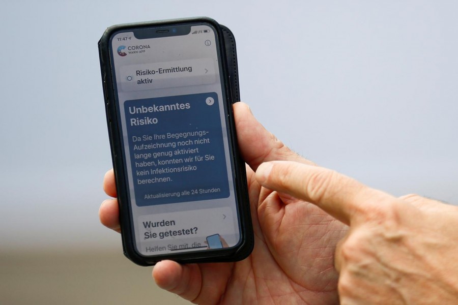 Timotheus Hoettges, Chief Executive Officer of Germany's telecommunications giant Deutsche Telekom AG, holds a mobile phone as he attends the presentation of the new contact-tracing smartphone app that will alert people of the risk of infection with the coronavirus disease (Covid-19), in Berlin, Germany on June 16, 2020 — Reuters photo