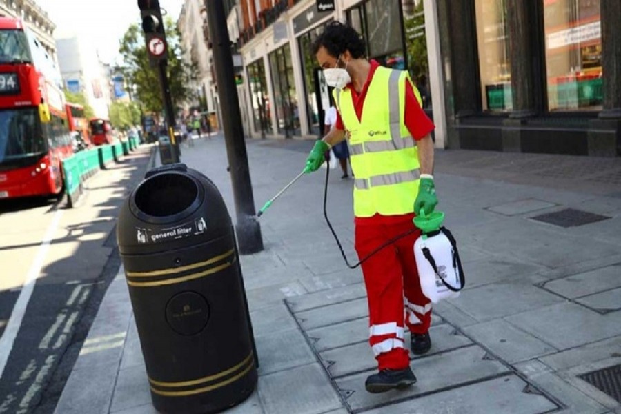A street cleaner disinfects a trash bin at Oxford Street, amid the spread of the coronavirus disease (COVID-19) in London, Britain, June 15, 2020 — Reuters