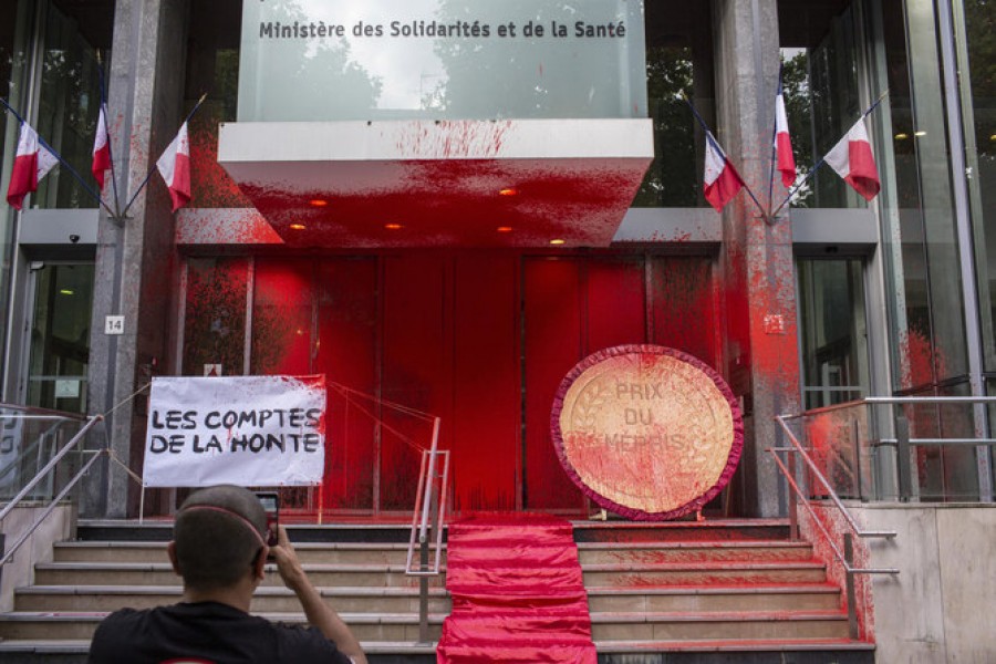 Activists deface the French health ministry building with red paint during a lighting protest on June 20, 2020. (AP)