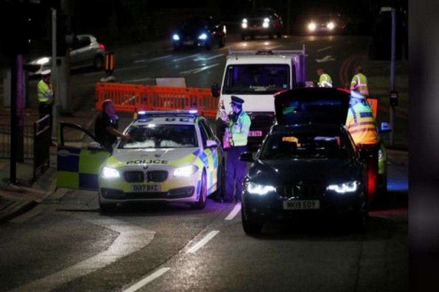 Police officers and their vehicles are seen at the scene of reported multiple stabbings in Reading, Britain, June 20, 2020. REUTERS/Peter Cziborra