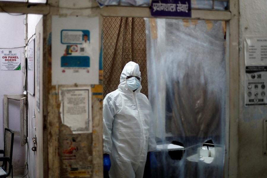 A health worker in personal protective equipment (PPE) waits for the next person to get tested for the coronavirus disease (COVID-19) at a local health centre, amid the spread of the disease, in New Delhi, India, June 27, 2020 – Reuters