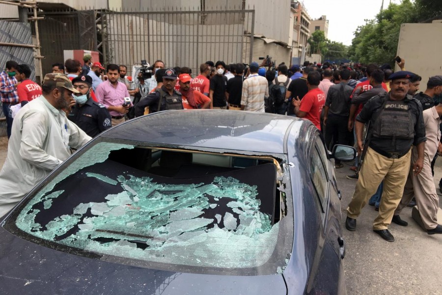 A plainclothes police officer (L) surveys the site of an attack at the Pakistan Stocks Exchange entrance in Karachi on June 29, 2020 — Reuters photo
