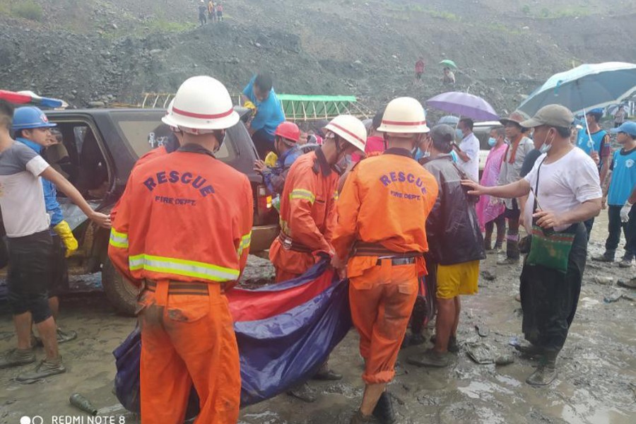 Rescue workers carry a dead body following a landslide at a mining site in Phakant, Kachin State City, Myanmar on July 2, 2020, in this picture obtained from social media — MYANMAR FIRE SERVICES DEPARTMENT via REUTERS