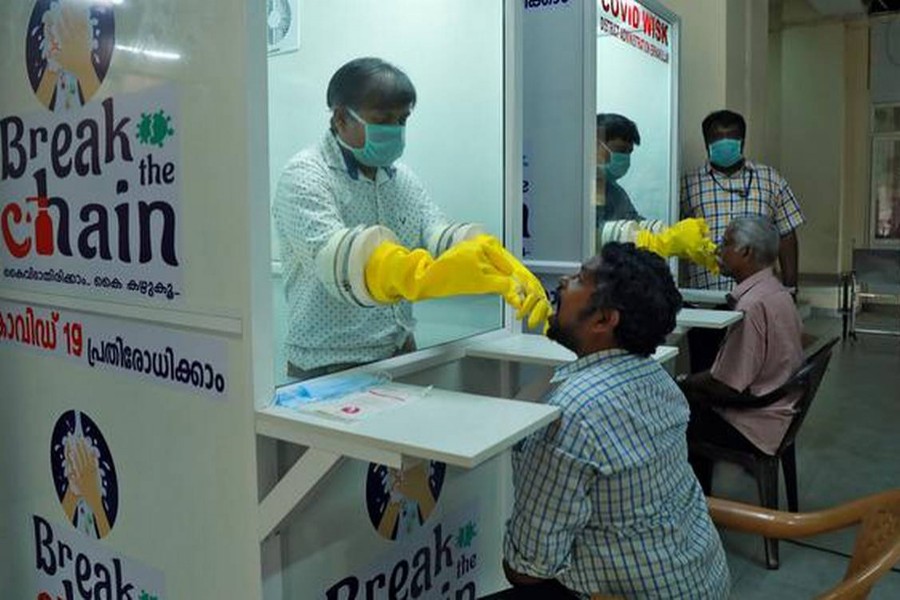 Medical staff members of a government-run medical college collect swabs from people to test for coronavirus disease (Covid-19) at a newly installed Walk-In Sample Kiosk in Ernakulam in the southern state of Kerala, India on April 6, 2020 — Reuters/Files