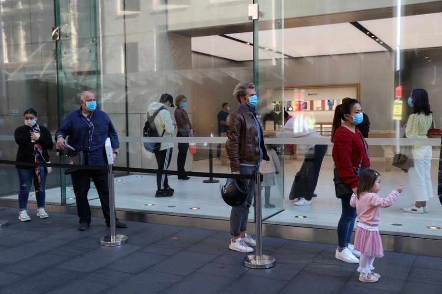 People wearing protective face masks practice social distancing while waiting to enter an Apple store on the first day of New South Wales' further eased coronavirus disease (Covid-19) restrictions in Sydney, Australia on July 1, 2020 — Reuters/Files