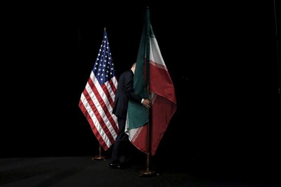 A staff member removes the Iranian flag from the stage after a group picture with foreign ministers and representatives of the US, Iran, China, Russia, Britain, Germany, France and the European Union during the Iran nuclear talks at the Vienna International Center in Vienna, Austria on July 14, 2015 — Reuters/Files