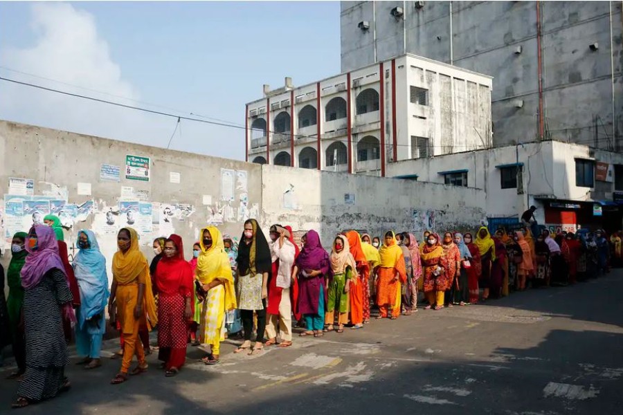 Garments workers queue to enter a factory after the reopening of factories on a limited scale, in Dhaka, Bangladesh, April 30 2020 - Monirul Alam/EPA-EFE