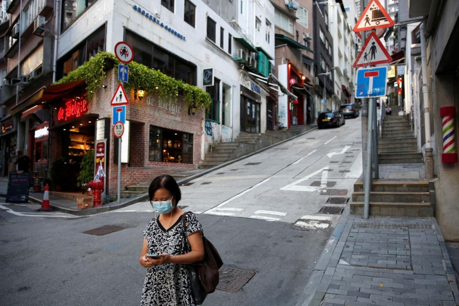 A woman wears a surgical mask while walking at Central following the coronavirus disease (COVID-19) outbreak in Hong Kong, China July 22, 2020. REUTERS/Tyrone Siu