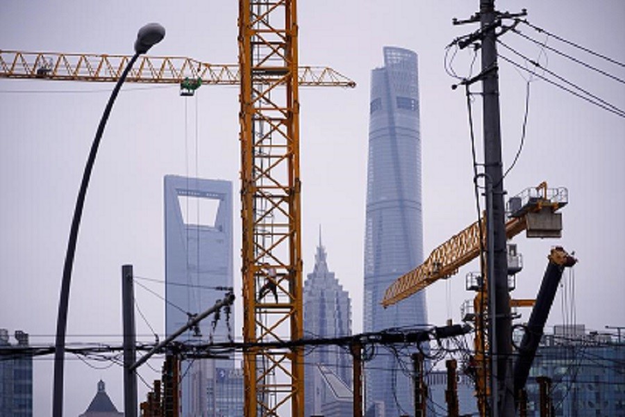 A worker is seen on a crane at a construction site in front of Lujiazui financial district, following the coronavirus disease (Covid-19) outbreak, in Shanghai, China, July 16, 2020 — Reuters