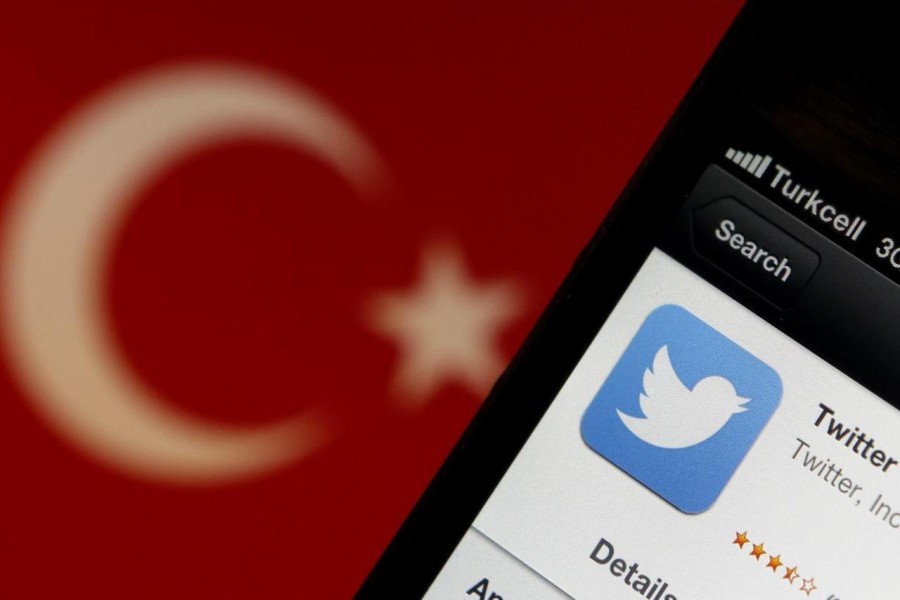 A Twitter logo on an iPhone display is pictured next to a Turkish flag in this photo illustration taken in Istanbul on March 21, 2014 — Reuters/Files